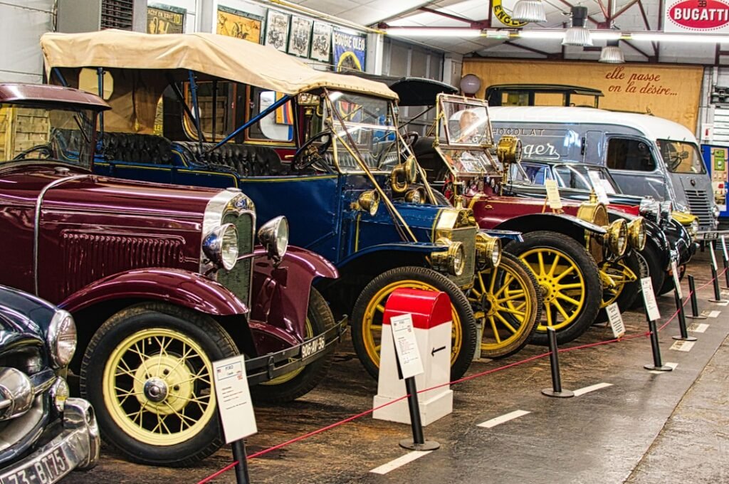 A row of classic vintage cars displayed in a museum.