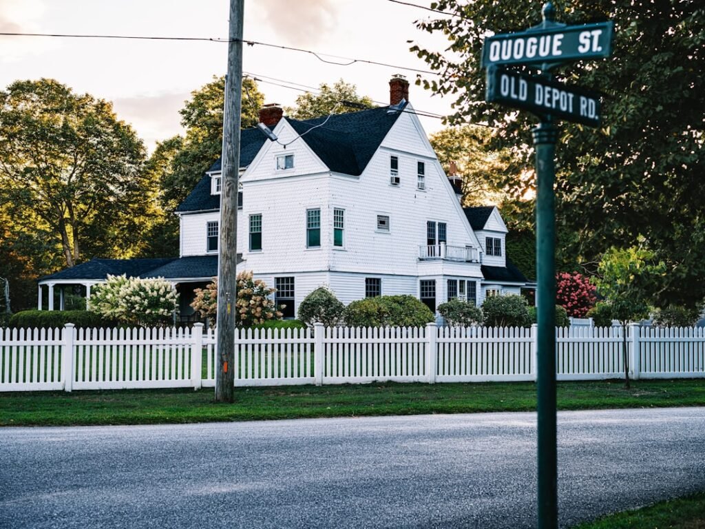 White house with picket fence and street signs