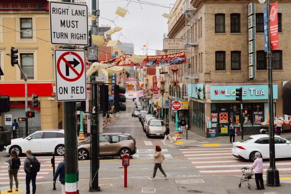 Street scene in a bustling city with cars and pedestrians.