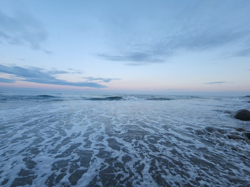 A sandy beach with waves coming in to shore