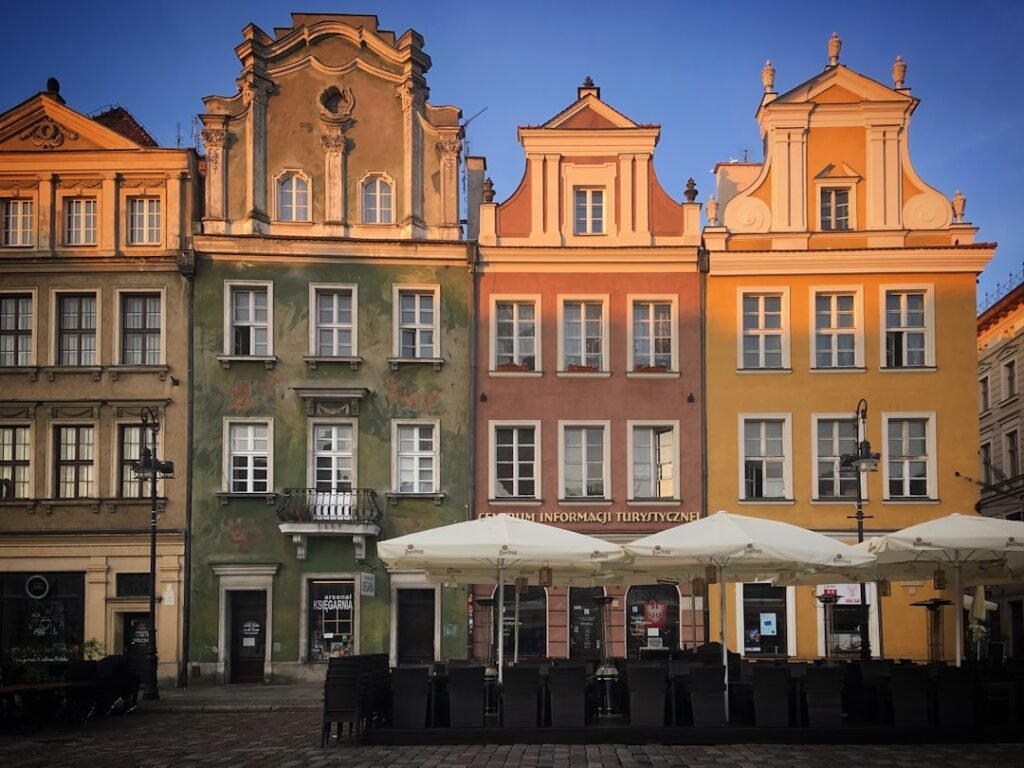 a row of buildings with tables and umbrellas in front of them